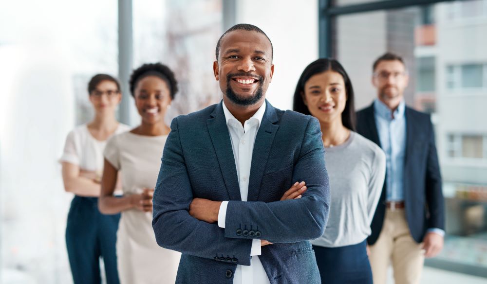 Diverse business team smiling and standing together in an office.