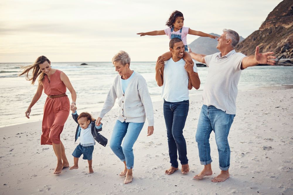 Intergenerational family walking down the beach