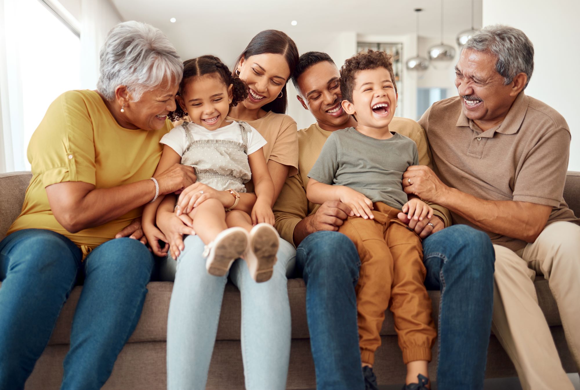 Intergenerational family sitting on a couch smiling