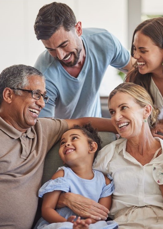Family smiling sitting on a couch