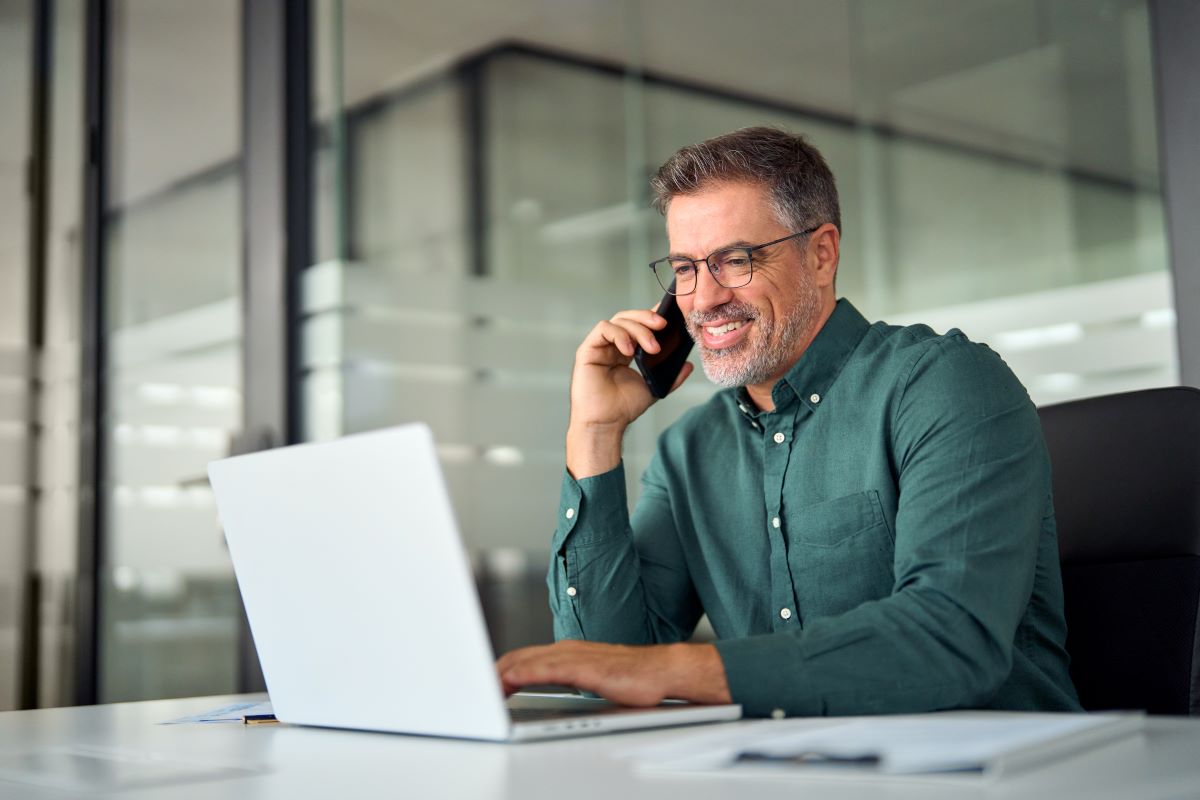 Man smiling while talking on the phone