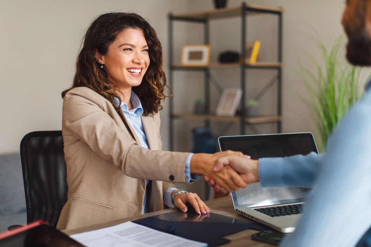 Young woman shaking a hand of man
